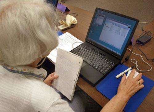 A senior citizen works on her laptop during a computer class