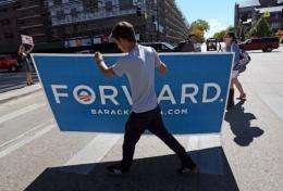A supporter of US President Barack Obama, carries a sign across the street prior to the presidential debate in Denver