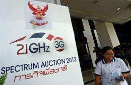 A Thai official walks past a sign of the 3G spectrum auction