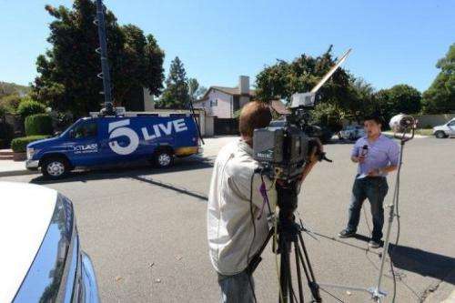 A TV journalists reports from outside of a house in Cerritos, California