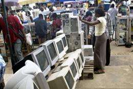 A used-computer vendor attends to a buyer at Lagos' computer village in 2006