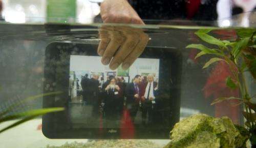 A waterproof tablet PC from Fujitsu is seen lowered into a fish tank at CeBIT