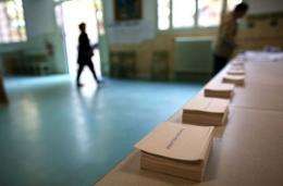 A woman arrives to pick up ballots prior voting at a polling station in Paris