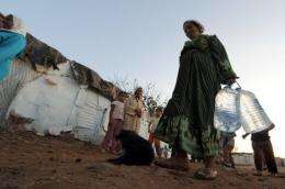 A woman carries bottles of tap water in a slum in the Moroccan town of Sale near Rabat