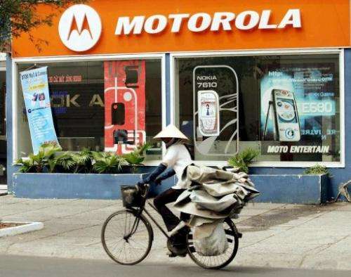 A woman rides past a Motorola shop in downtown Ho Chi Minh City