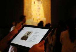 A woman uses an iPad with information on Austrian artist Gustav Klimt
