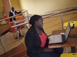 A woman works on her laptop at an internet cafe in Kampala