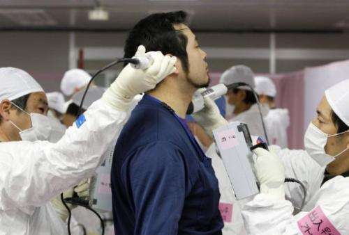 A worker is screened for radiation before entering the emergency operation centre