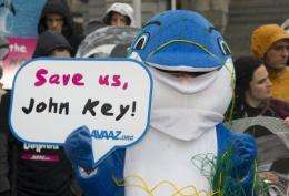 Campaigners dressed as dolphins urge the New Zealand Prime Minister to protect the critically endangered Maui's dolphin