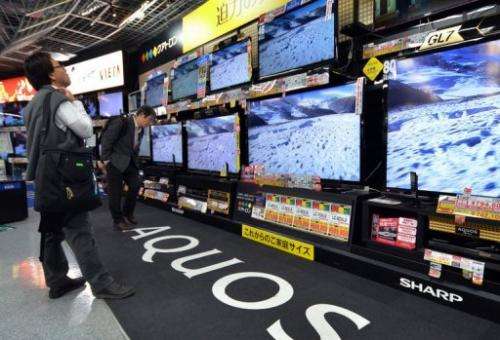 Customers check LCD television sets made at a Tokyo electronics shop on November 1, 2012