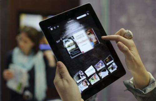 Customers try out an eBook reader app on an Apple iPad at the Leipzig Book Fair on March 15, 2012 in Leipzig, Germany