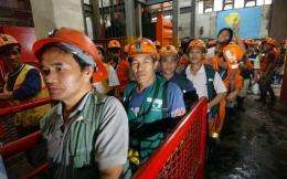 Filipino miners make their way out after their work in the mine tunnel of Philex Mining Corp. in Padcal