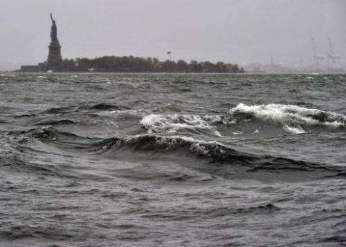 High surf batters the Hudson River near the Statue of Liberty in New York