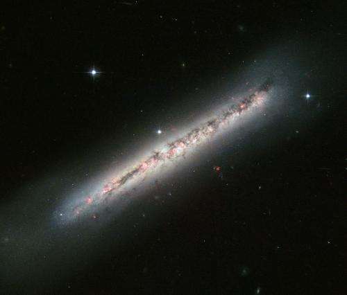 Hubble Catches Glowing Gas and Dark Dust in a Side-On Spiral