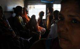 Indian women and children waiting inside a train carriage at a railway station in New Delhi, in July
