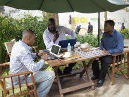 Men work on their laptops at the Endiro Cade in Kampala