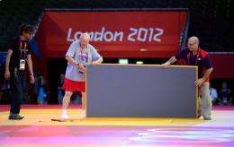 Organisers install tatamis for the judo competition at the Excel centre on July 26 in London