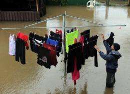 Paul Lavers salvages the laundry from his flooded backyard after heavy rains caused flash flooding across Sydney