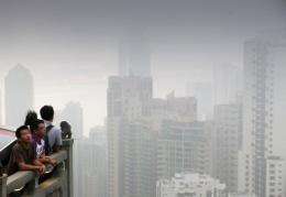 People look across the Hong Kong skyline shrouded by smog