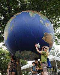 People pose with a giant globe