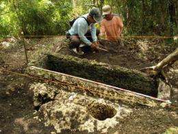 Philippine archaeologists work on an unearthed limestone coffin