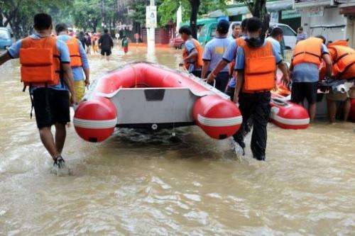Philippine police rescue teams prepare a boat to evacuate residents