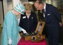 Queen Elizabeth II (L) and Prince Philip look at the Enigma codebreaking machine at Bletchley Park in 2011