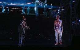 Rapper Snoop Dogg (L) and a hologram of deceased rapper Tupac Shakur (R) perform onstage during music festival