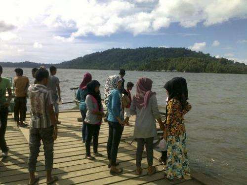Residents of the remote Simeuleu island near Aceh observe the sea level in their bay