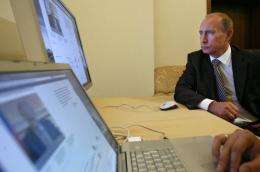 Russian President Vladimir Putin looks at a computer in his office