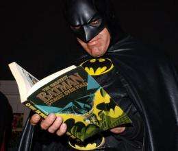 Superhero Batman reads a Batman comic book