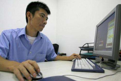 Technician is seen working on his desktop PC at a foreign-invested software company in Chengdu, on July 14, 2006