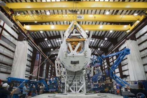 Technicians attach the Dragon capsule to a Falcon 9 rocket at the SpaceX facility in Florida