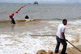 Technicians display the ACE submarine fiber optic cable on the shore of Libreville, Gabon, in 2011