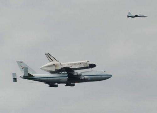 The Space Shuttle Discovery is seen above the Washington suburbs