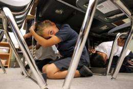 Third grade students take cover under desks as they participate in an earthquake drill in 2011