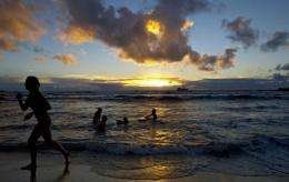 Tourists swim in Hangaroa beach as the sun sets on Easter Island, 3700 km off the Chilean coast in the Pacific Ocean