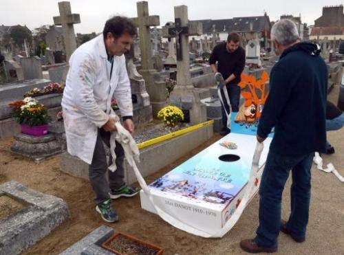 Workers install an 'iron grave' at a cemetery in Nantes for TV show creator Serge Danot who died in 1990