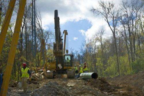 Workers lay the pipes of a gas pipeline outside the town of Waynesburg