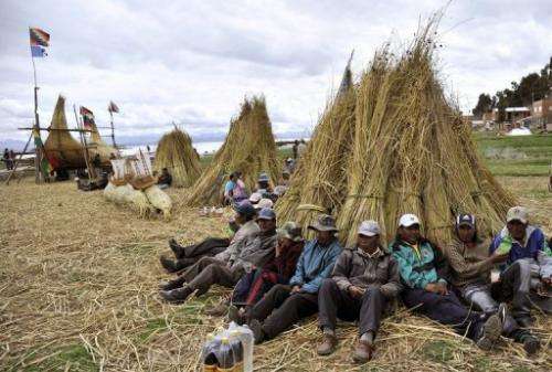 Workers take a break from building a bulrush boat on Suriqui island in Lake Titicaca, Bolivia,  December 2, 2012