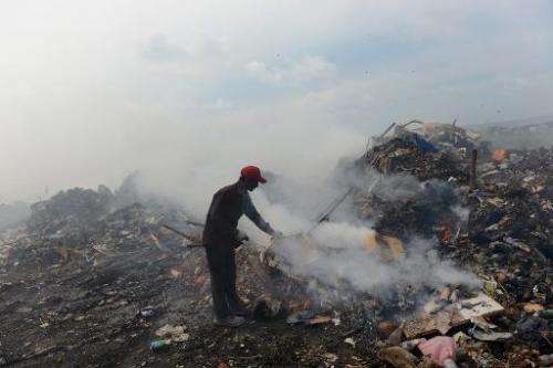 A Bangladeshi immigrant helps keep a fire going in the country's largest trash dump at Thilafushi Island on September 6, 2013
