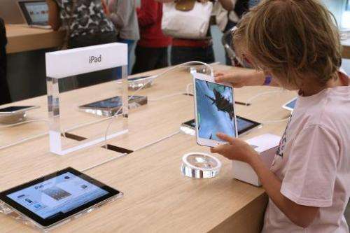 A child plays with an Apple iPad Mini at an Apple store in Paris on July 6, 2013