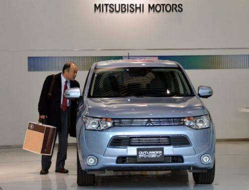 A customer looks at Mitsubishi Motors' new plug-in hybrid SUV in Tokyo on February 5, 2013