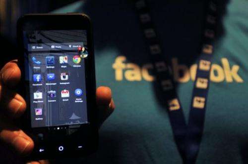 A Facebook employee displays an HTC phone with the new Home operating system at Facebook's headquarters, April 04, 2013