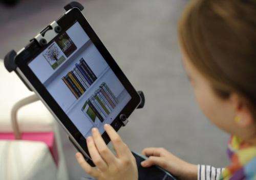 A fair goer tries out an eBook reader app on an Apple iPad at the Leipzig Book Fair on March 15, 2012