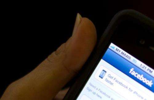 A girl logs into Facebook on her smartphone in Kuala Lumpur on May 15, 2012