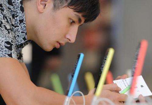 A man looks at the new iPhone 5C at the Apple Store in Glendale, California, September 20, 2013