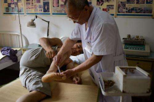 A patient receives a bee sting administered by a doctor of traditional Chinese medicine at a clinic on August 2, 2013