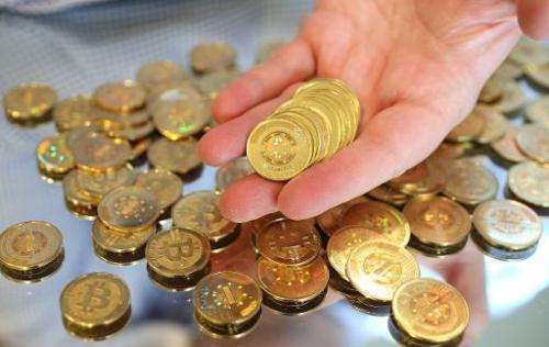 A software engineer holds physical Bitcoins, minted at his shop in Sandy, Utah, on April 26, 2013