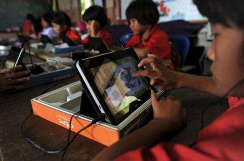 A student uses a tablet at Ban San Kong school in Mae Chan, in Thailand's northern Chiang Rai province on May 27, 2013